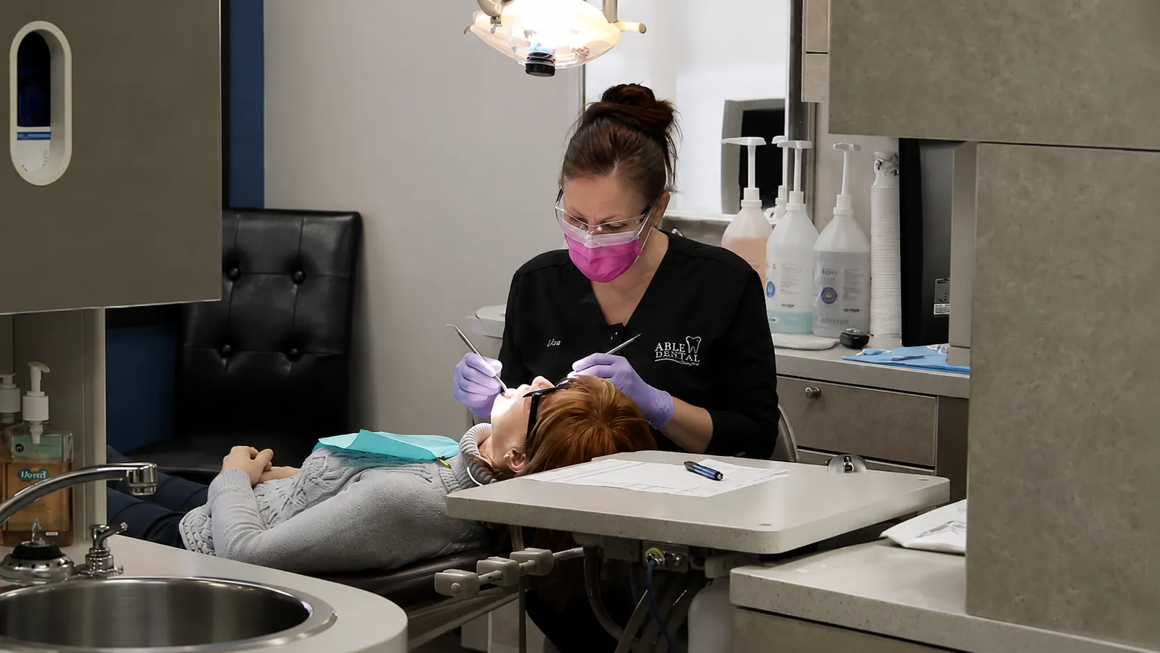 Dental hygienist performing a cleaning procedure at Able Family Dental
